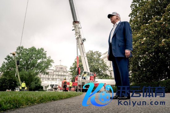 6月18日，唐纳德·特朗普在华盛顿特区白宫南草坪上与媒体成员交谈，工东谈主们正在装配一座新旗杆。